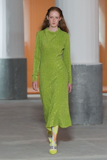 A model walking in a shimmery green gown by Stine Goya