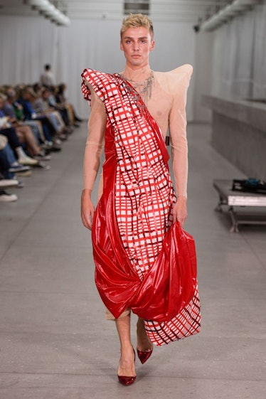 A model walking in a checkered toga-like outfit by Frederik Taus