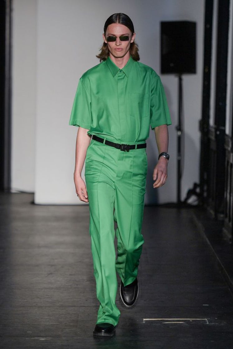 A model walking in a short-sleeved green button-up and matching pants by Soeren Le Schmidt