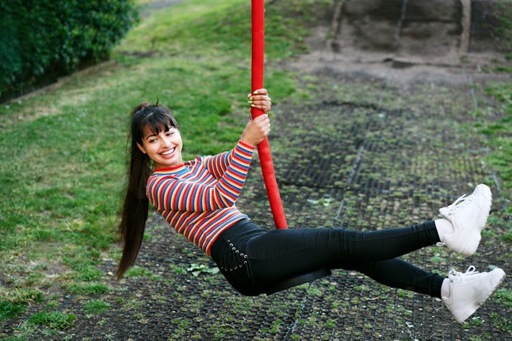 Young woman on a rope swing before posting a swing quote for Instagram captions.