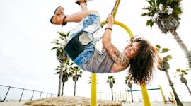 Young woman smiling and swinging at the park before posting swing quotes for Instagram captions.