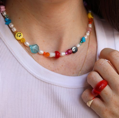 A woman wears a beaded necklace. Mindful beading is one activity in art therapy for anxiety.