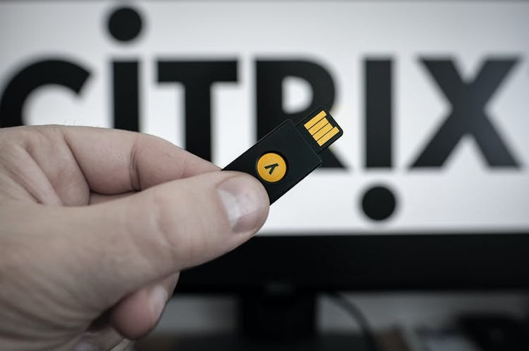 A hand holding a YubiKey device