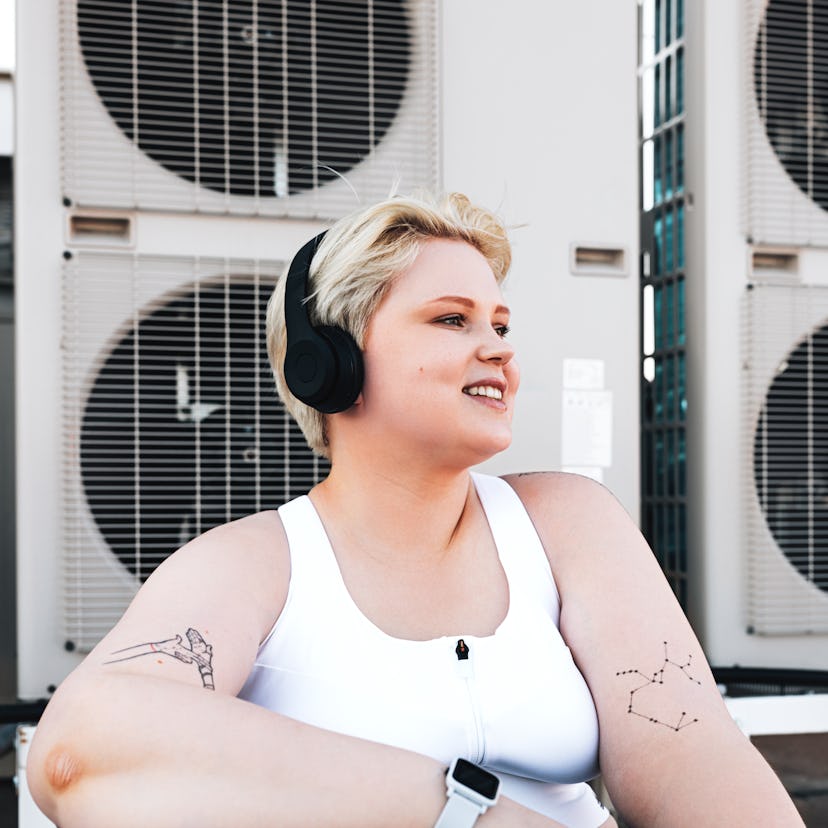 Young woman smiling while wearing headphones during the August 2021 full moon in Aquarius, which wil...