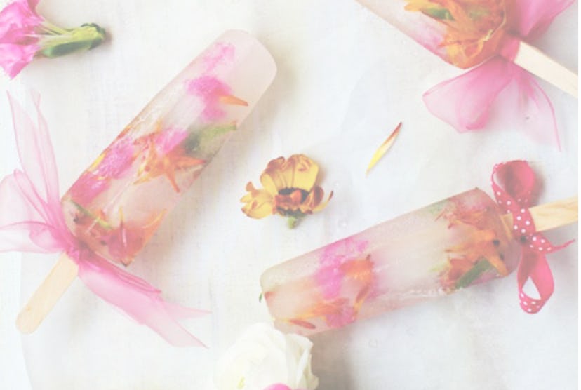 Image from the website studiodiy.com of clear popsicles with edible flowers.