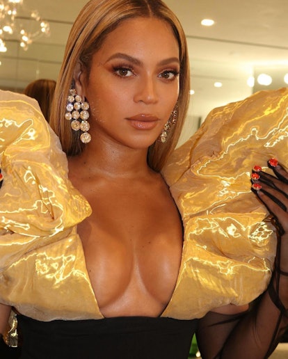 Beyoncé in gold dress and gloves selfie