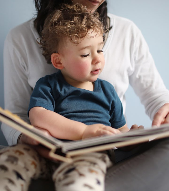 toddler sitting on mom's lap, reading a children's book