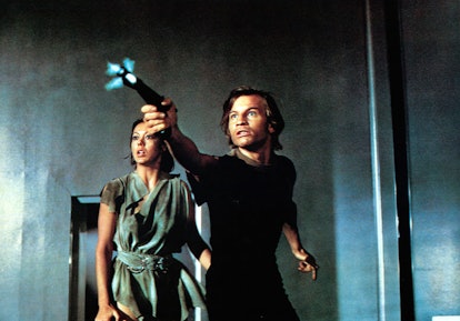 Jenny Agutter watches as Michael York shoots a gun in a scene from the film 'Logan's Run.'