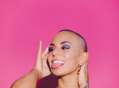 Young happy beautiful woman against a pink background sticking out her tongue on her 25th birthday, ...
