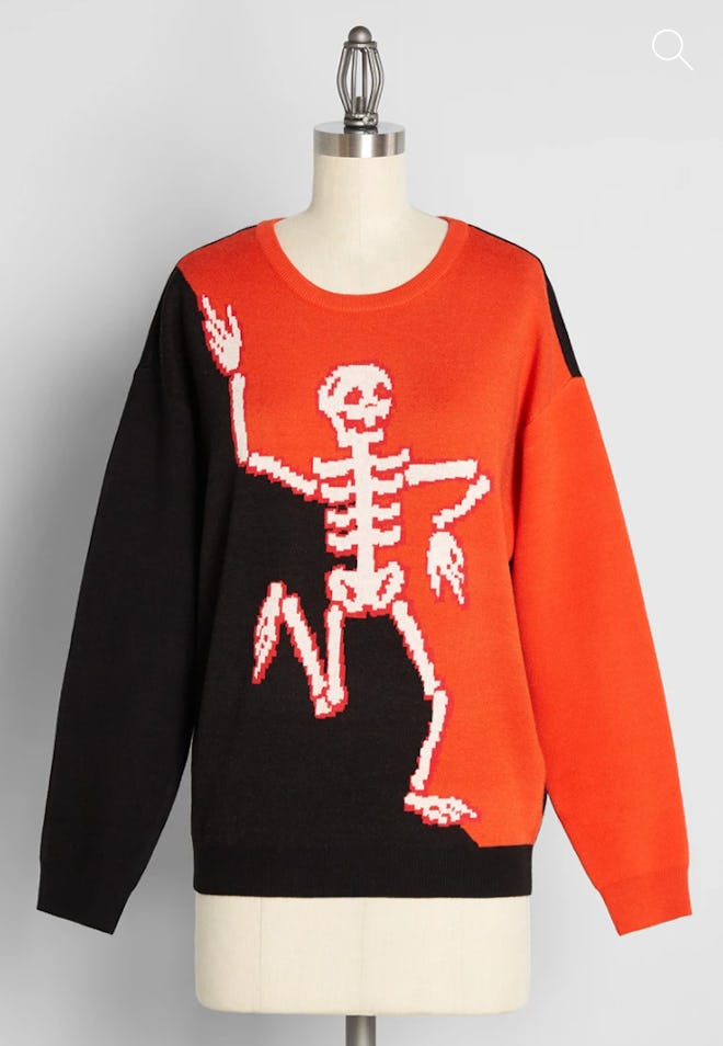 Mannequin displaying black and white sweater with dancing skeleton