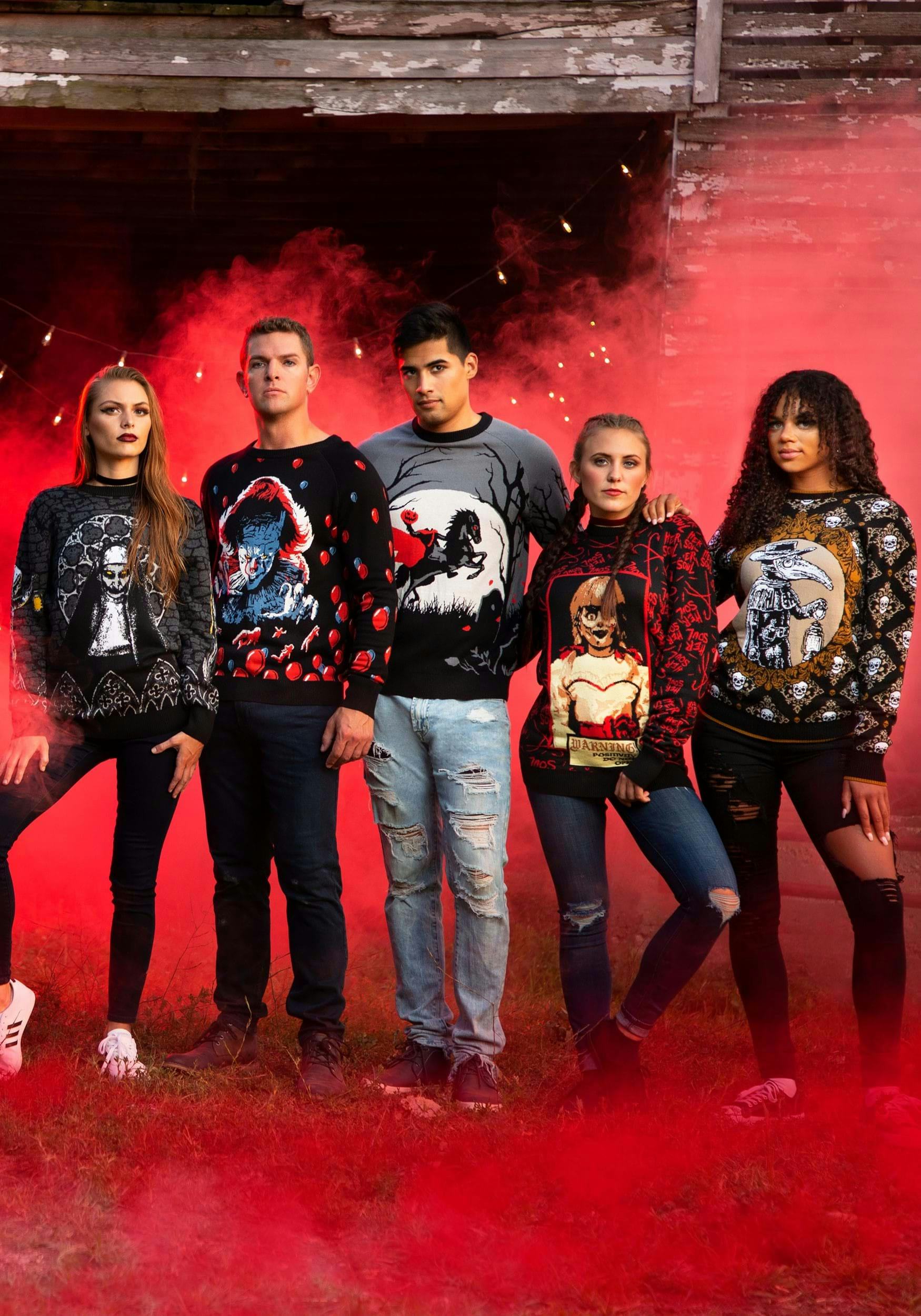 Five adults lined up, all wearing ugly sweaters for Halloween