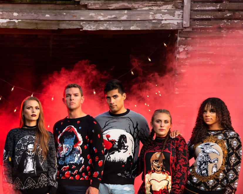 Five adults lined up, all wearing ugly sweaters for Halloween