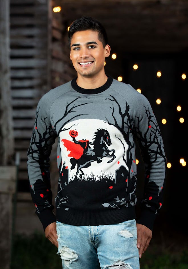 Man standing in sweater featuring headless horseman in front of full moon
