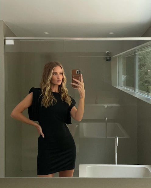 Rosie Huntington-Whiteley wears a black mini dress and poses in a mirror selfie.