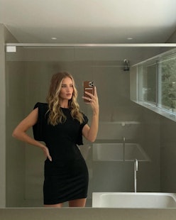 Rosie Huntington-Whiteley wears a black mini dress and poses in a mirror selfie.