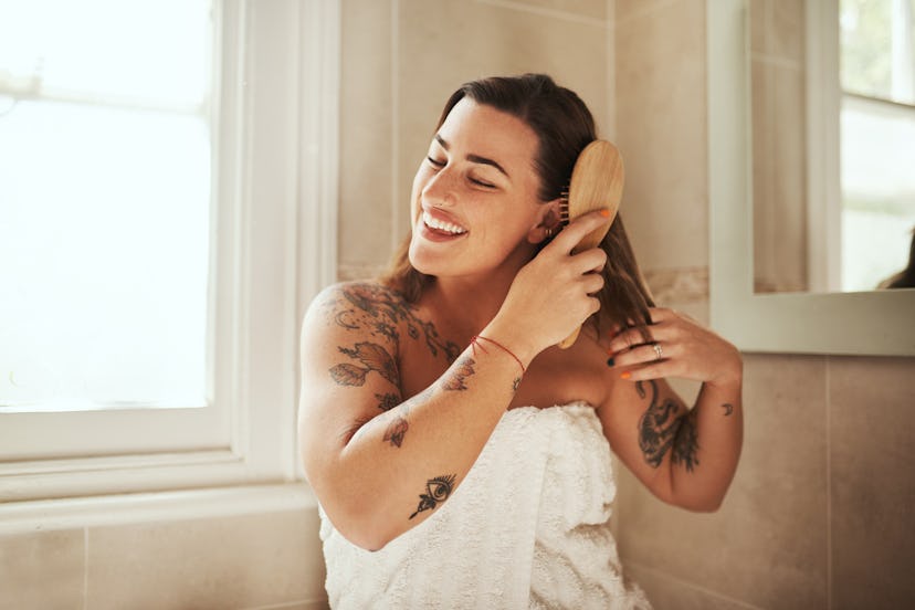 Woman brushing her hair in a towel