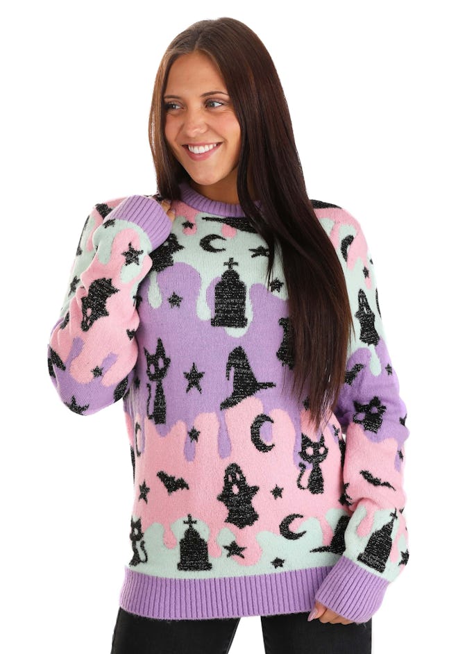 Woman wearing multi-colored pastel sweater with ghosts and witch hats