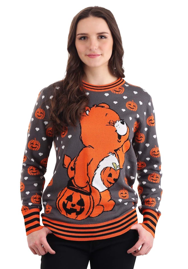 Woman wearing sweater featuring orange Care Bear for Halloween