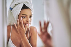 Woman touching face in mirror