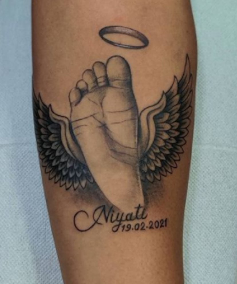 Tattoo of baby footprint with angel wings around it