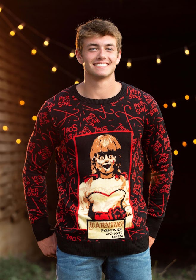 Man in sweater featuring Annabelle doll 