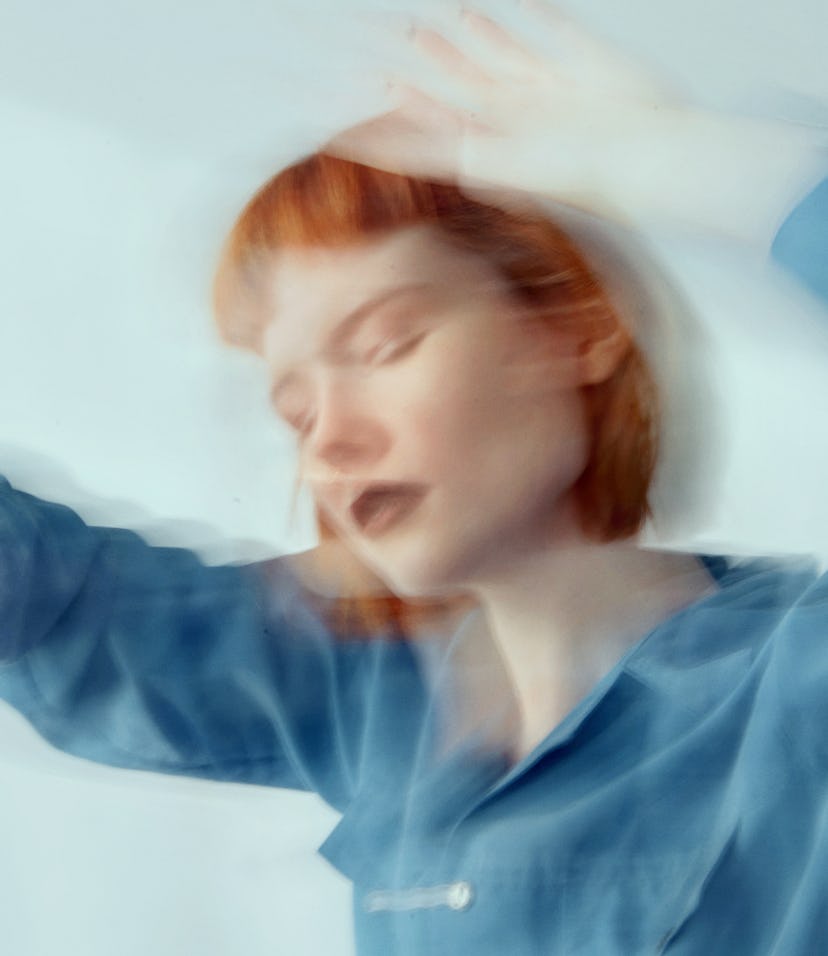 Red haired woman in blue shirt dancing, blurred motion during the blue moon on Aug. 22, 2021.