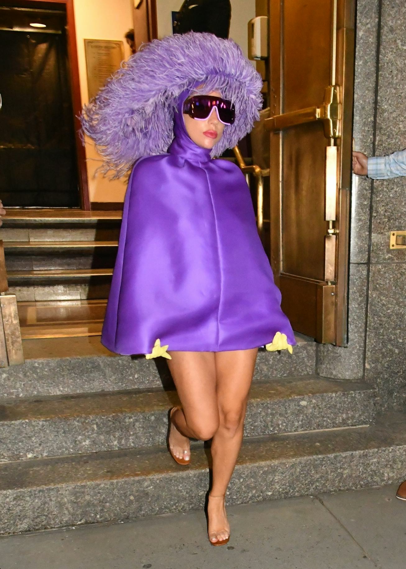Lady Gaga wears a purple dress and matching headdress for her departure from Radio City Music Hall i...