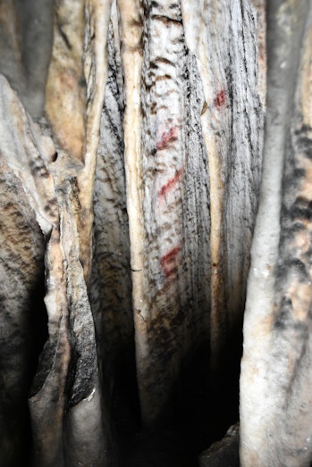 Close-up view of one of the curtains with red markings in Cueva de Ardales.