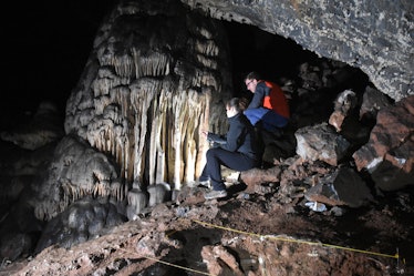Researchers looking toward the massive speleothem of Cueva Ardales, with archaeological trench in th...