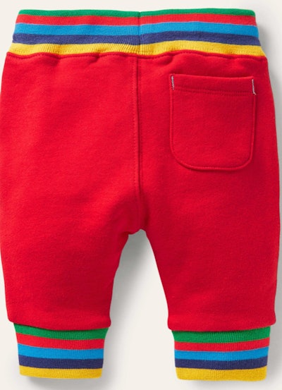 Image of the back of a pair of toddler-size red drawstring jersey pants with rainbow-design waistban...