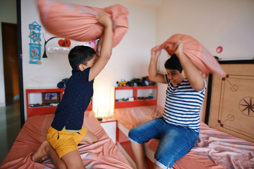 brothers having a pillow fight in their bedroom