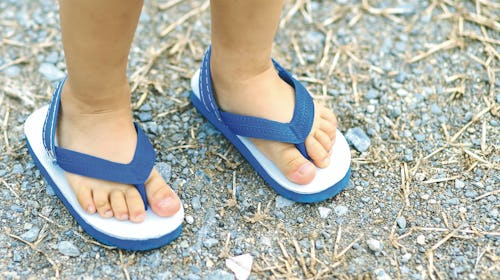 A kids feet wearing blue Flip-Flops