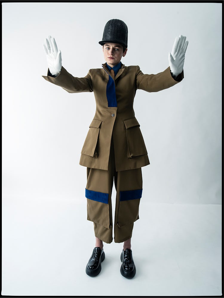 Emma Corrin wears a Loewe jacket, shirt, pants, and tie; Jo Miller Studio hat; AGL shoes; stylist’s ...