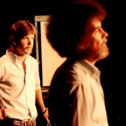 A youngSteve Ross stands in the background behind his father, painter Bob Ross.