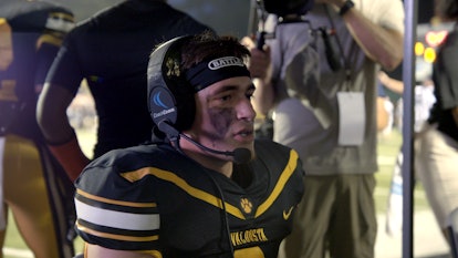 Jake Garcia getting coached via headset during a football game on 'Titletown High'.