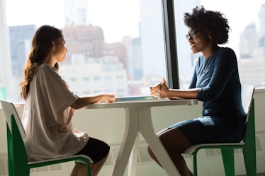 Two people sitting at a table talking.