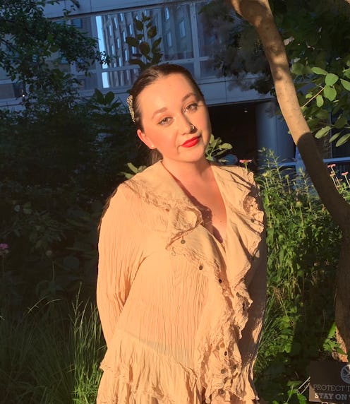 Emma Childs wears a tan, ruffled blouse.