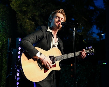 Finneas playing a guitar at an event