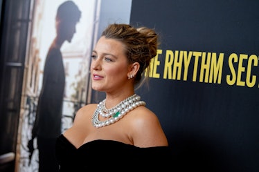 Blake Lively in a black dress with oversized pearls wearing a loose high bun haircut at the Brooklyn...