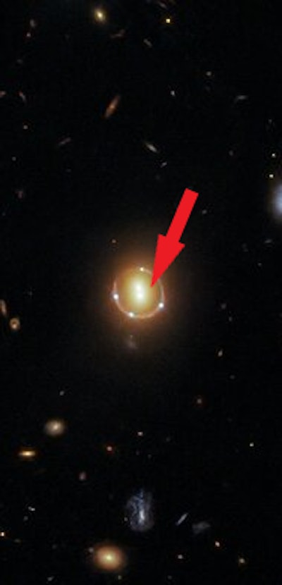 A Hubble image of the cluster with a red arrow pointing at the exact location
