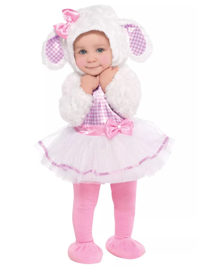 Baby girl standing, smiling, wearing a lamb costume