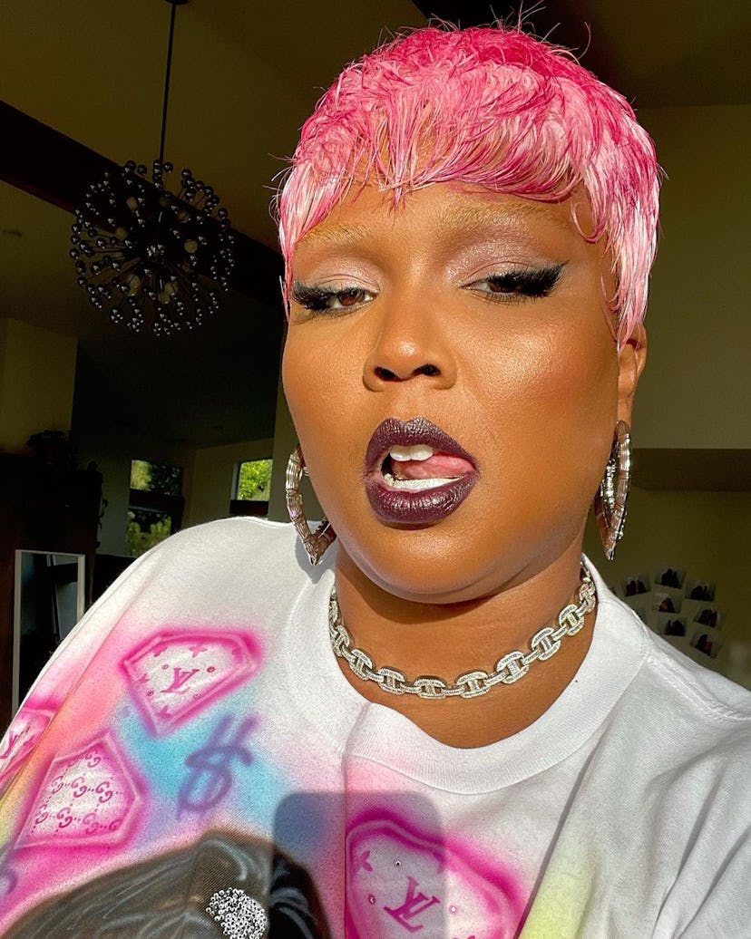 Lizzo with short pink hair, wearing a purple metallic lipstick for fall
