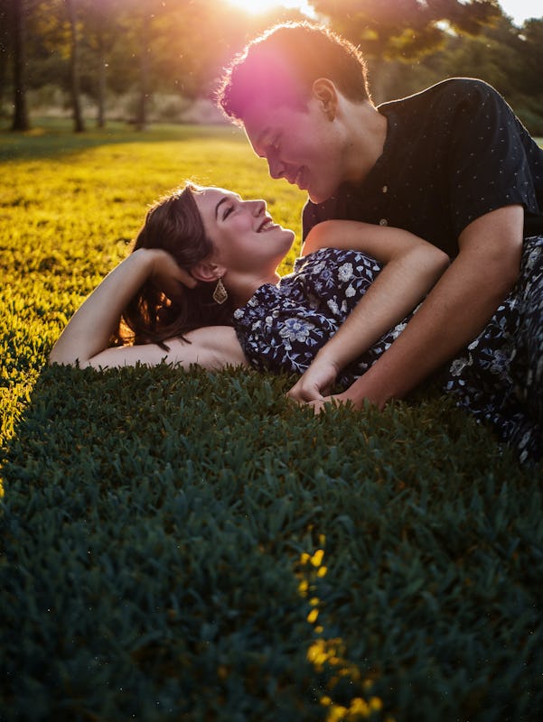 man and woman on the grass cuddling
