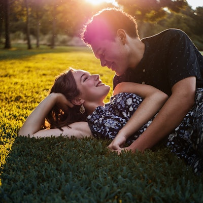 man and woman on the grass cuddling