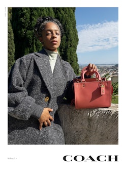 Kelsey Lu stars in Coach's Rogue bag campaign, posing next to red Rogue 25 handbag in Colorblock.
