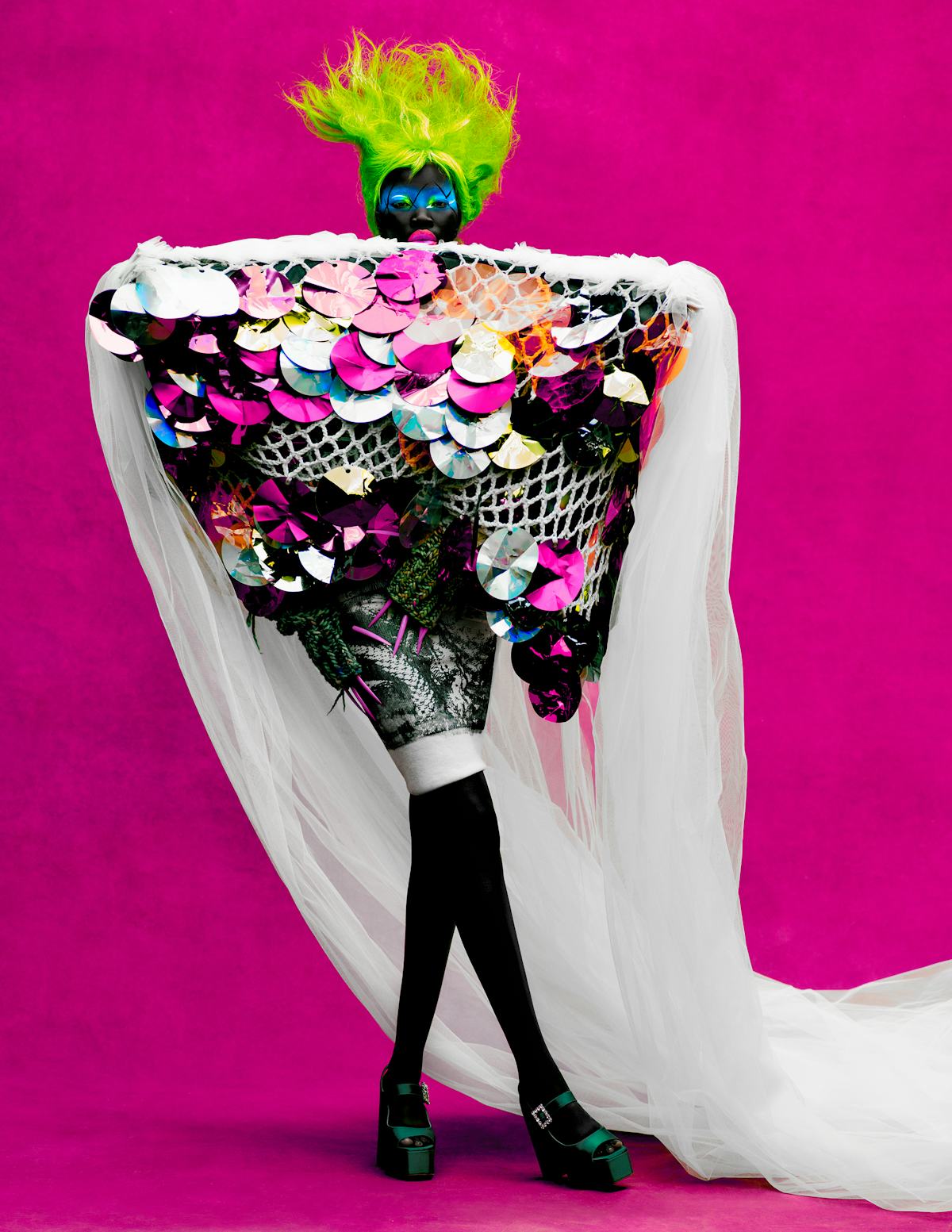 Adhel Bol wears a Matty Bovan dress, skirt, and arm warmers; Gina platform shoes.