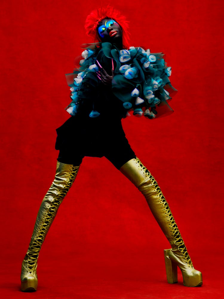 Adhel Bol wearing a Giorgio Armani cape and skirt; Natacha Marro boots.