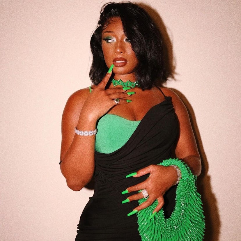 Megan Thee Stallion posing with a green Bottega Veneta purse