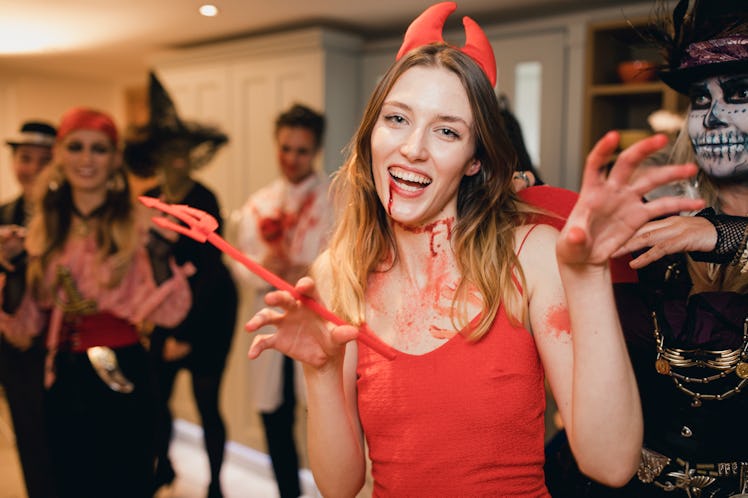 Young blonde woman in devil costume, in need of caption for posing in her Halloween outfit on Instag...