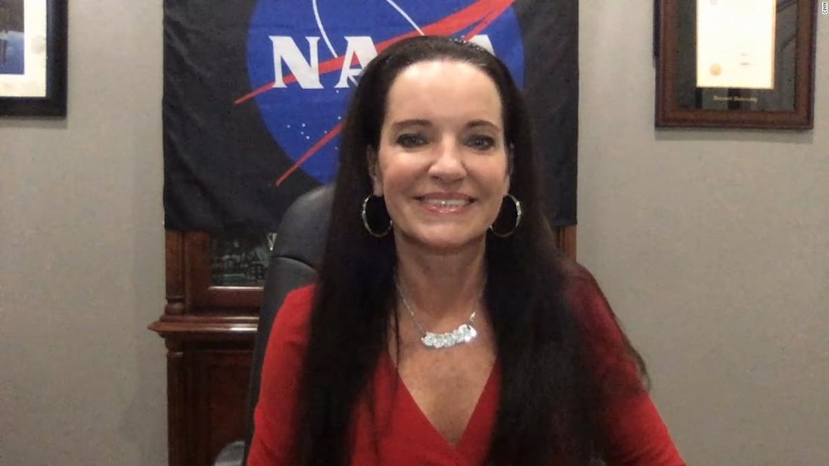 Smiling woman with a NASA flag in the background.